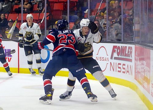 Regina Pats Keegan Slaney checks Brandon's Hayden Wheddon in their Western Hockey League opener at Westoba Place on Friday. (Thomas Friesen/The Brandon Sun)