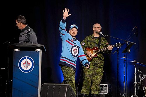 Royal Canadian Air Force Master Cpl. Kris Simundson waves to the crowd during the jersey unveiling Saturday. Joining Simundson on stage was Royal Canadian Air Force master warrant officer Anita Zacher and Maj.-Gen. Iain Huddleston, who is in command of 1 Canadian Air Division in Winnipeg. (Brook Jones/Winnipeg Free Press)