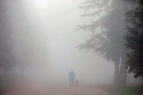 26092023
A woman walks a dog through the fog at the Brandon Municipal Cemetery on a cool Tuesday morning. Thick fog blanketed the wheat city throughout the morning. 
(Tim Smith/The Brandon Sun)