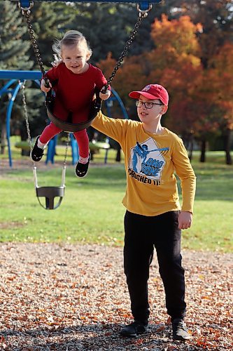 27092023
Lewis Gunderson, 11, pushes family friend Amelia Peech, 3, on the swings at Rideau Park on a sunny Wednesday morning. 
(Tim Smith/The Brandon Sun)