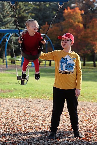27092023
Lewis Gunderson, 11, pushes family friend Amelia Peech, 3, on the swings at Rideau Park on a sunny Wednesday morning. 
(Tim Smith/The Brandon Sun)