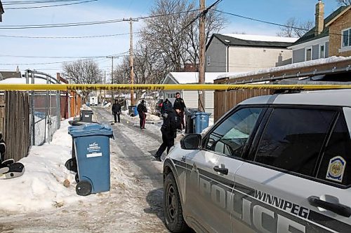 Winnipeg police investigate in the lane of Beverley and Toronto streets, between Ellice and St. Matthews avenues, in March. (Erik Pindera / Winnipeg Free Press)