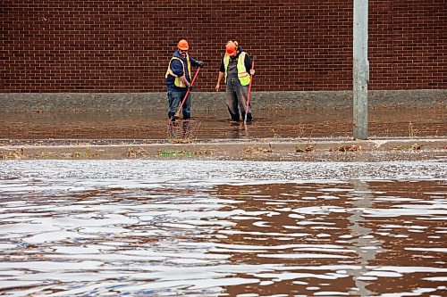 28092023
Workers try to clear drains to relieve flooding along Richmond Avenue west of 18th Street after a thunderstorm and downpour on Thursday morning. 
(Tim Smith/The Brandon Sun)
