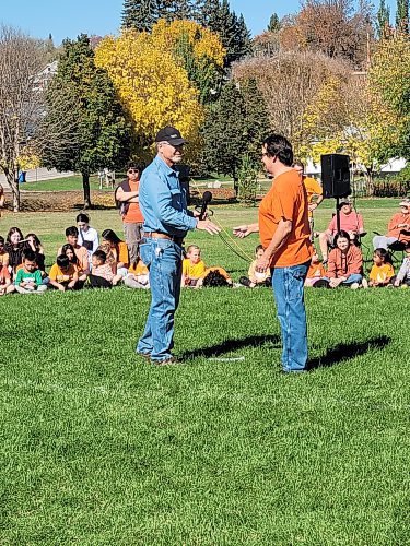 Neepawa deputy mayor Murray Parrott (left) presents Ebb and Flow First Nation elder Darren Mousseau (right) with tobacco at a Truth and Reconciliation week event for students in Neepawa on Friday. (Miranda Leybourne/The Brandon Sun)