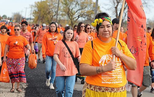 Hundreds of people march down Wokiksuye Ċanku (Remembrance Road) during Brandon’s Orange Shirt Day festivities. The crowd’s final destination was the former site of the old Brandon Indian Residential School, which was founded in 1895, ceased operations in 1972 and demolished in 2006. (Kyle Darbyson/The Brandon Sun)