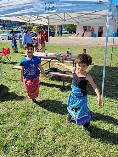 Sisters Jasper Rain Roulette, 6, (left) and Goddess Chartrand, 4, (right) dance in ribbon skirts at Neepawa's Indigenous Culture Day on Sept. 30. (Miranda Leybourne/The Brandon Sun)