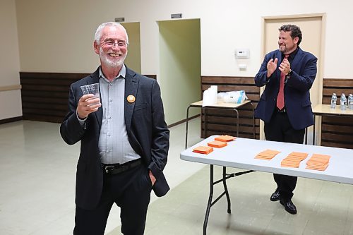 Brandon West NDP candidate Quentin Robinson (left) salutes supporters while Brandon East NDP candidate Glen Simard applauds after polls come in showing both candidates in the lead in their ridings during their campaign party at the Royal Canadian Legion Branch No. 3 on Tuesday evening. (Tim Smith/The Brandon Sun)