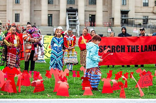 MIKAELA MACKENZIE / WINNIPEG FREE PRESS

Harlee-Quinn Laplante (seven) puts red dress signs into the grass at the Manitoba Legislative Building for National Day of Action for Missing and Murdered Indigenous Women, Girls and Gender Diverse People on Wednesday, Oct. 4, 2023.
Winnipeg Free Press 2023.