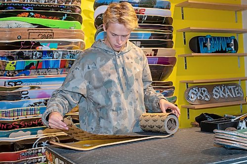 BROOK JONES / WINNIPEG FREE PRESS
Fane Smeall, who owns Sk8 Skates with his family, puts griip tape on the deck of a skateboard, while working at the local shop at 564 Main Street in Winnipeg, Man., Thursday, Oct. 6, 2023. Sk8 Skates is having a 40 per cent off sale called Last Season Snow. The 23-year-old fears the business might close because sales have dropped off during the past year and attributes it to a higher cost of living for people.