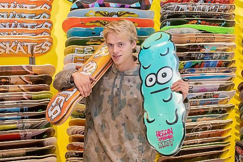 BROOK JONES / WINNIPEG FREE PRESS
Fane Smeall, who owns Sk8 Skates with his family, holds a few skateboard decks, while working at the local shop at 564 Main Street in Winnipeg, Man., Thursday, Oct. 6, 2023. Sk8 Skates is having a 40 per cent off sale called Last Season Snow. The 23-year-old fears the business might close because sales have dropped off during the past year and attributes it to a higher cost of living for people.