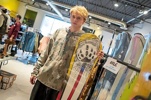 BROOK JONES / WINNIPEG FREE PRESS
Fane Smeall, who owns Sk8 Skates with his family, stands next to a number of snowboards, while working at the local shop at 564 Main Street in Winnipeg, Man., Thursday, Oct. 6, 2023. Sk8 Skates is having a 40 per cent off sale called Last Season Snow. The 23-year-old fears the business might close because sales have dropped off during the past year and attributes it to a higher cost of living for people.