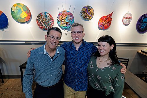 MIKE DEAL / WINNIPEG FREE PRESS
Cole Cancilla (centre) with Xcues cafe owner, Sal Infantino (left) and Kelsey Cespe (right), Entertainment coordinator at Xcues cafe and lounge.
Artist Cole Cancilla with his distinctive canvases that are on display in Xcues caf&#xe9; and lounge at 551 Sargent Avenue.
Artist Cole Concilla&#x2019;s 20 round canvases are a peek into his mind. Covering a whole range of styles from figurative to abstract via textural textile work and spray paint Concilla says this body of work shows his versatility as an artist by pushing the challenges of pluralism. 
231005 - Thursday, October 05, 2023.