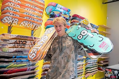 BROOK JONES / WINNIPEG FREE PRESS
Fane Smeall, who owns Sk8 Skates with his family, holds a few skateboard decks, while working at the local shop at 564 Main Street in Winnipeg, Man., Thursday, Oct. 6, 2023. Sk8 Skates is having a 40 per cent off sale called Last Season Snow. The 23-year-old fears the business might close because sales have dropped off during the past year and attributes it to a higher cost of living for people.