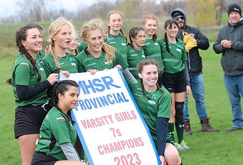 The Dauphin Clippers pose with their varsity girls rugby 7s provincial championship banner at John Reilly Field. (Perry Bergson/The Brandon Sun)