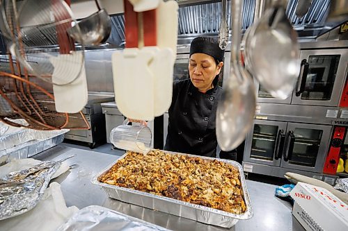 MIKE DEAL / WINNIPEG FREE PRESS
Marilou Castro food services manager at Siloam Mission works on a tray of stuffing, the 18th of the day, for the upcoming dinner rush. The traditional Thanksgiving meals are for people experiencing poverty and homelessness at Siloam Mission.
Volunteers and staff in the kitchen at Siloam Mission prepare and serve hundreds of traditional Thanksgiving meals for those experiencing poverty and homelessness Friday.
231006 - Friday, October 06, 2023.