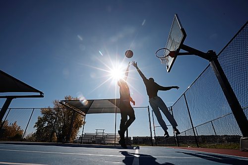 Jackson Doty and Victor Aderemi-Fawoye shoot hoops together at the Jumpstart Multi Sport Court in Brandon’s south end on a beautiful Tuesday afternoon. (Tim Smith/The Brandon Sun)