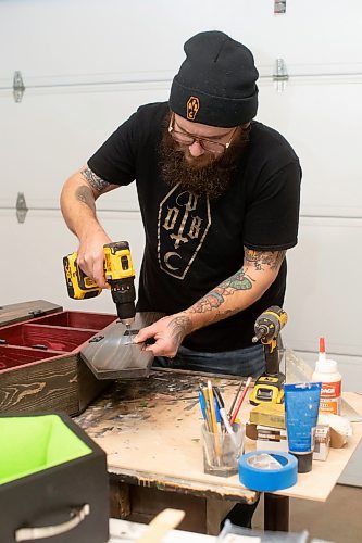 BROOK JONES / WINNIPEG FREE PRESS
Blake Locken, who works as a carpenter by day, runs a home-based business called Old Pine Box Curiousitiies. Locken is pictured working on a coffin shaped cabinet in his garage, which dubs as his workshop, in Winnipeg, Man., Wednesday, Oct. 11 . He also builds upholstered pet beds and charcuterie boards, all with a coffin shape theme. The Winnipeg resident will be a vendor at the Punk Rock Flea Market at the University of Manitoba in Winnipeg, Man., Saturday, Oct. 14, 2023 from 10:30 a.m. to 5 p.m. The event also run Sunday, Oct. 15, 2023.