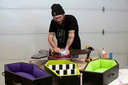 BROOK JONES / WINNIPEG FREE PRESS
Blake Locken, who works as a carpenter by day, runs a home-based business called Old Pine Box Curiousitiies. Locken is pictured working on a coffin shaped cabinet in his garage, which dubs as his workshop, in Winnipeg, Man., Wednesday, Oct. 11 . He also builds upholstered pet beds and charcuterie boards, all with a coffin shape theme. The Winnipeg resident will be a vendor at the Punk Rock Flea Market at the University of Manitoba in Winnipeg, Man., Saturday, Oct. 14, 2023 from 10:30 a.m. to 5 p.m. The event also run Sunday, Oct. 15, 2023.