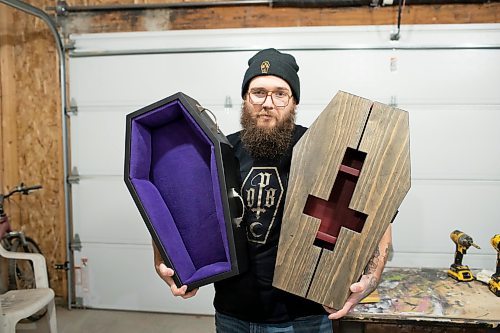 BROOK JONES / WINNIPEG FREE PRESS
Blake Locken, who works as a carpenter by day, runs a home-based business called Old Pine Box Curiousitiies. Locken is pictured holding a coffin-shaped pet bed as well as a coffin shaped cabinet in his garage, which dubs as his workshop, in Winnipeg, Man., Wednesday, Oct. 11 . He also builds charcuterie boards, coffee tables, book shelves and wine racks.  The Winnipeg resident will be a vendor at the Punk Rock Flea Market at the University of Manitoba in Winnipeg, Man., Saturday, Oct. 14, 2023 from 10:30 a.m. to 5 p.m. The event also run Sunday, Oct. 15, 2023.