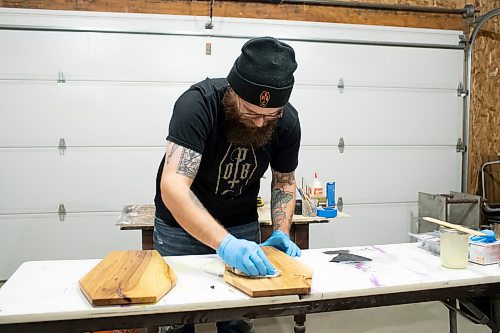 BROOK JONES / WINNIPEG FREE PRESS
Blake Locken, who works as a carpenter by day, runs a home-based business called Old Pine Box Curiousitiies. Locken is pictured sanding a coffin-shaped charcuterie board while working in his garage, which dubs as his workshop, in Winnipeg, Man., Wednesday, Oct. 11 . He also builds upholstered pet beds and cabinets, all with a coffin shape theme. The Winnipeg resident will be a vendor at the Punk Rock Flea Market at the University of Manitoba in Winnipeg, Man., Saturday, Oct. 14, 2023 from 10:30 a.m. to 5 p.m. The event also run Sunday, Oct. 15, 2023.