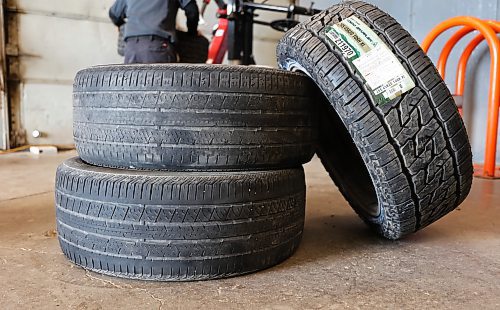 Two worn tires from Ken Cunningham's all-wheel drive vehicle sit beside one of the new tires he's getting installed at Kal Tire in Brandon on Thursday. (Michele McDougall/The Brandon Sun)