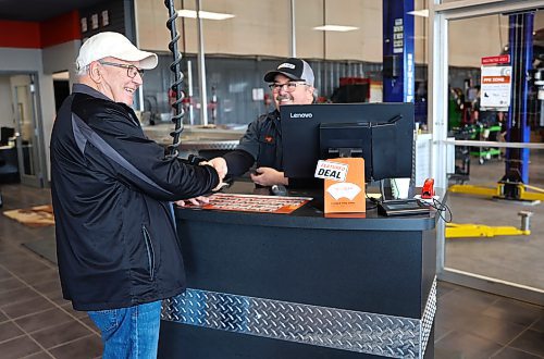 Brandon's Ken Cunningham shakes hands with Jeff Munro, service agent at Kal Tire in Brandon on Thursday. (Michele McDougall/The Brandon Sun)
