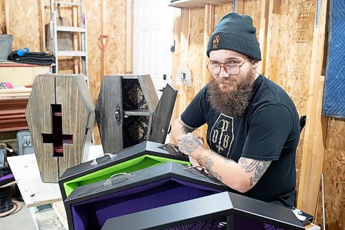 BROOK JONES / WINNIPEG FREE PRESS
Blake Locken, who works as a carpenter by day, runs a home-based business called Old Pine Box Curiousitiies. Locken is pictured next to coffin-shaped pet beds as well as a coffin shaped cabinets in his garage, which dubs as his workshop, in Winnipeg, Man., Wednesday, Oct. 11. He also builds charcuterie boards, coffee tables, book shelves and wine racks. The Winnipeg resident will be a vendor at the Punk Rock Flea Market at the University of Manitoba in Winnipeg, Man., Saturday, Oct. 14, 2023 from 10:30 a.m. to 5 p.m. The event also run Sunday, Oct. 15, 2023.