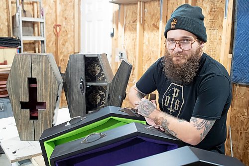 BROOK JONES / WINNIPEG FREE PRESS
Blake Locken, who works as a carpenter by day, runs a home-based business called Old Pine Box Curiousitiies. Locken is pictured next to coffin-shaped pet beds as well as a coffin shaped cabinets in his garage, which dubs as his workshop, in Winnipeg, Man., Wednesday, Oct. 11. He also builds charcuterie boards, coffee tables, book shelves and wine racks. The Winnipeg resident will be a vendor at the Punk Rock Flea Market at the University of Manitoba in Winnipeg, Man., Saturday, Oct. 14, 2023 from 10:30 a.m. to 5 p.m. The event also run Sunday, Oct. 15, 2023.