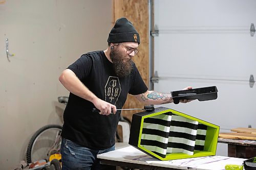 BROOK JONES / WINNIPEG FREE PRESS
Blake Locken, who works as a carpenter by day, runs a home-based business called Old Pine Box Curiousitiies. Locken is pictured painting a coffin-shaped cabinet with a Bettlejuice theme colour in his garage, which dubs as his workshop, in Winnipeg, Man., Wednesday, Oct. 11. He also builds charcuterie boards, coffee tables, book shelves and wine racks. The Winnipeg resident will be a vendor at the Punk Rock Flea Market at the University of Manitoba in Winnipeg, Man., Saturday, Oct. 14, 2023 from 10:30 a.m. to 5 p.m. The event also run Sunday, Oct. 15, 2023.