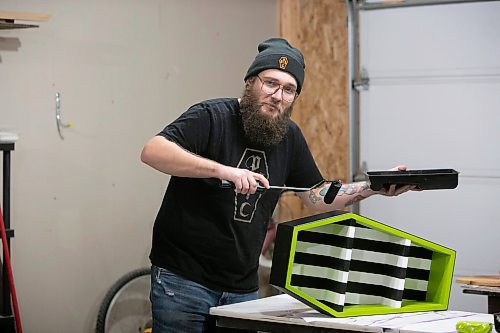 BROOK JONES / WINNIPEG FREE PRESS
Blake Locken, who works as a carpenter by day, runs a home-based business called Old Pine Box Curiousitiies. Locken is pictured painting a coffin-shaped cabinet with a Bettlejuice theme colour in his garage, which dubs as his workshop, in Winnipeg, Man., Wednesday, Oct. 11. He also builds charcuterie boards, coffee tables, book shelves and wine racks. The Winnipeg resident will be a vendor at the Punk Rock Flea Market at the University of Manitoba in Winnipeg, Man., Saturday, Oct. 14, 2023 from 10:30 a.m. to 5 p.m. The event also run Sunday, Oct. 15, 2023.