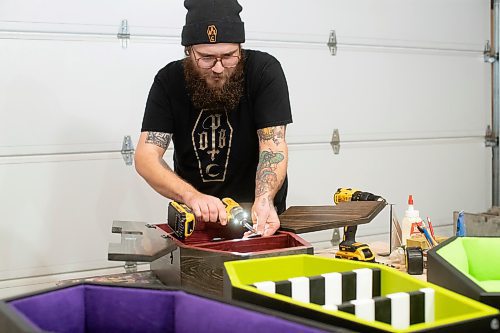 BROOK JONES / WINNIPEG FREE PRESS
Blake Locken, who works as a carpenter by day, runs a home-based business called Old Pine Box Curiousitiies. Locken is pictured working on a coffin shaped cabinet in his garage, which dubs as his workshop, in Winnipeg, Man., Wednesday, Oct. 11. He also builds upholstered pet beds and charcuterie boards, all with a coffin shape theme. The Winnipeg resident will be a vendor at the Punk Rock Flea Market at the University of Manitoba in Winnipeg, Man., Saturday, Oct. 14, 2023 from 10:30 a.m. to 5 p.m. The event also run Sunday, Oct. 15, 2023.