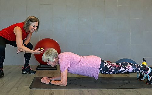 Peggy Fleming, 89, does a plank at Brandon's YMCA while Sue Palmer, fitness class supervisor, monitors the time on a stopwatch. (Photos by Tim Smith/The Brandon Sun)