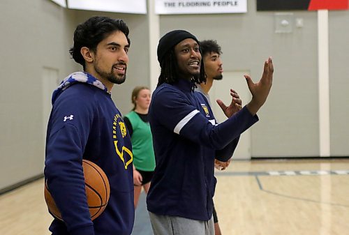 Sultan Bhatti, left, and Ian Gasana of the Bobcats men's basketball team, watch local students play ball as they raise funds to support the family of Antoine Sutherland. (Thomas Friesen/The Brandon Sun)