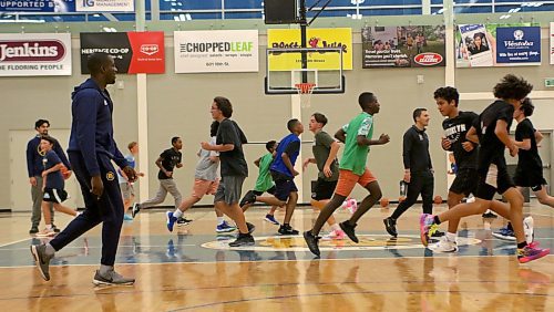 Silas Owusu-Acheaw, left, encourages the 32 basketball players who attended the camp in support of Antoine Sutherland's family as they run wind sprints. (Thomas Friesen/The Brandon Sun)