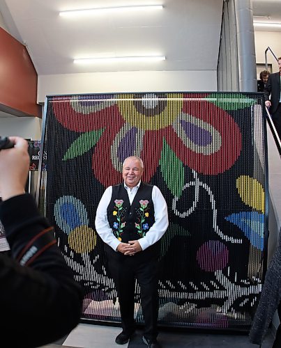 Manitoba Métis Federation president David Chartrand unveils a portion of the installation, which is expected to be completed in 2026. (Katrina Clarke / Winnipeg Free Press)