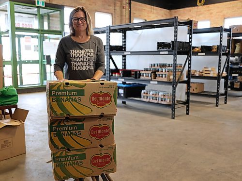 Staff member of Samaritan House Ministries, Carla - who chose not to give her last name, wheels three cases of bananas into the pick-up area of the food bank in Brandon on Wednesday. (Michele McDougall/The Brandon Sun) 
