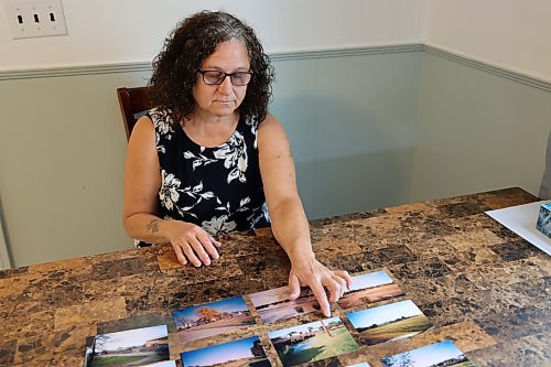 Using photos from the last 20 years,  Jean Halliday recalls flooding events around her home on 16th Street North near Lady of the Lake. Since the new Daly Overpass started construction, she said the water has been coming closer to her home than before. (Colin Slark/The Brandon Sun)