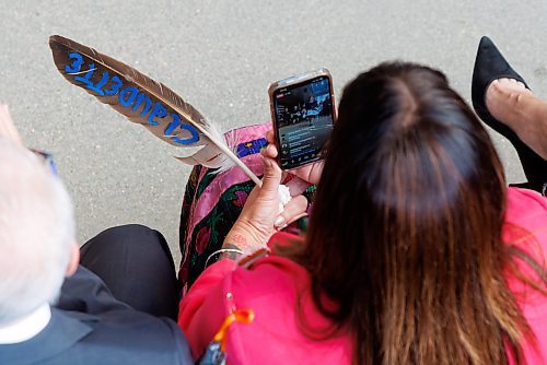 MIKE DEAL / WINNIPEG FREE PRESS
MLA Bernadette Smith and soon to be Minister of housing, addictions and homelessness and minister responsible for mental health, holds an eagle feather with the name Claudette painted on it while recording on her phone the dancing being performed by the Norman Chief Memorial Dancers.
Manitoba NDP Leader Wab Kinew was sworn in Wednesday as the province&#x2019;s 25th premier in a ceremony filled with Indigenous culture and traditions.
The Fort Rouge MLA became the first First Nations premier of a Canadian province after taking the oath of office from Lt.-Gov. Anita Neville in front of an invitation-only crowd at The Leaf horticultural exhibit in Assiniboine Park.
231018 - Wednesday, October 18, 2023.