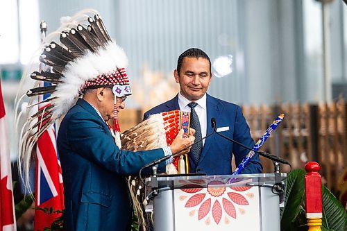 Fred Kelly, former grand chief of the Anishinaabe Nation in treaty three, presents Wab Kinew with a war bonnet at Kinew’s swearing-in ceremony at The Leaf on Wednesday, Oct. 18, 2023. (Mikaela MacKenzie/Winnipeg Free Press)