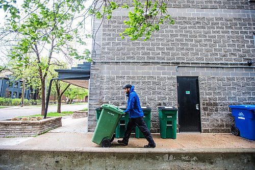 MIKAELA MACKENZIE / WINNIPEG FREE PRESS

Garrett LeBlanc, compost courier with Compost Winnipeg, wheels a bin over to the truck while on his route in Winnipeg on Tuesday, May 31, 2022. For JS story.
Winnipeg Free Press 2022.