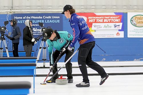 Jace Freeman, left, and Rylan Campbell sweep a stone during their Westman Superleague of Curling game on Wednesday night. (Thomas Friesen/The Brandon Sun) 
