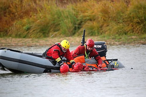 Dressed in water training immersion suits, students from the Manitoba Emergency Services College in Brandon undergo surface water rescue education in the Assiniboine River as part of their course work at Dinsdale Park on Wednesday afternoon. (Matt Goerzen/The Brandon Sun)