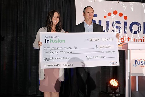 Danielle's Studio 12 owner Danielle Platic received her $20,000 cheque from Fusion Credit Union chief executive officer Darwin Johns at the Community Infusion competition at the Dome building on Wednesday. (Abiola Odutola/The Brandon Sun)
