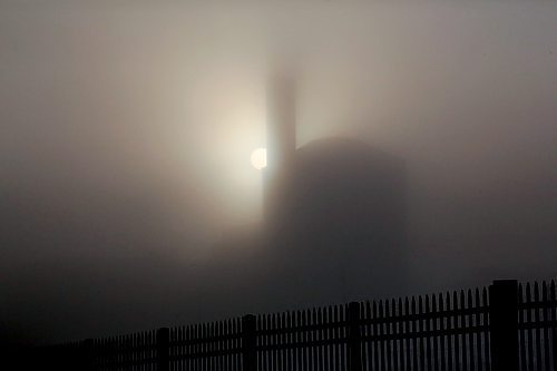 The shadowy silhouette of the McKenzie Seeds building towers above the city on a foggy Thursday morning, as seen from Assiniboine Avenue. (Matt Goerzen/The Brandon Sun)