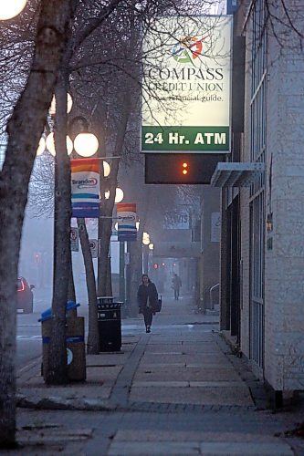 Pedestrians walk the sidewalk on Rosser Avenue near 10th Street on a foggy Thursday morning in Brandon. (Matt Goerzen/The Brandon Sun)