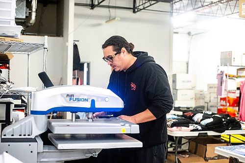 MIKAELA MACKENZIE / WINNIPEG FREE PRESS

Sean Rayland, owner of Red Rebel Armour, prints a hoodie in the production space on Century Street on Friday, Oct. 20, 2023. Rayland spent his youth going in and out of prison. Now in his 30s, the father of eight established his clothing business in 2018 after deciding to change the direction of his life. For AV story.
Winnipeg Free Press 2023.