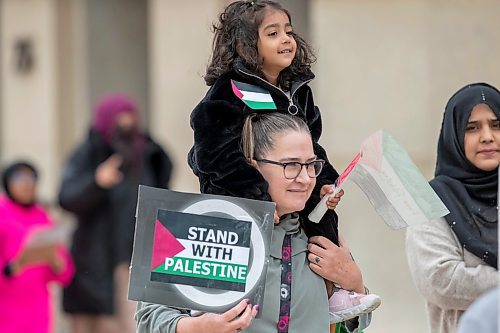 BROOK JONES / WINNIPEG FREE PRESS
Heather Cherpako carries her friend's daughter Myriam Abbas on her shoulders as they walk to the All Out For Palestine rally at Memroial Park in Winnipeg, Man.., Saturday, Oct. 21, 2023. Her friend Muqadd Abbas is pictured to the right. Hundreds gathered for the rally, which included a march down Broadway Avenue and Main Street as the rally continued at intersection of Portage Avenue and Main Street.