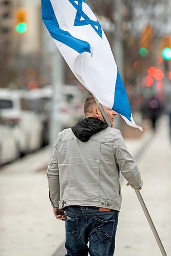 BROOK JONES / WINNIPEG FREE PRESS
Al, who did not want his last name used, carring an Israeli flag as he walks along Broadway Avenue promoting the Jewish world community of peace and life. He was walking alongside the All Out For Palestine rally, which got underway at Memorial Park in Winnipeg, Man.., Saturday, Oct. 21, 2023. and continued down Broadway Avenue. Those supporting the All Out For Palestine also marched down Broadway Avenue and Main Street as the rally continued at intersection of Portage Avenue and Main Street.