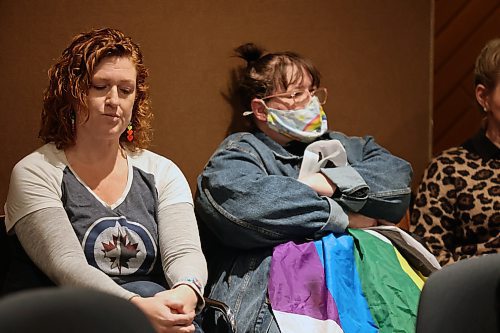 Two audience members, one holding a 2SLGBTQIA+ ally flag, listen to a presentation at Monday's Brandon School Division board of trustees meeting objecting to queer history being taught in local schools. (Colin Slark/The Brandon Sun)