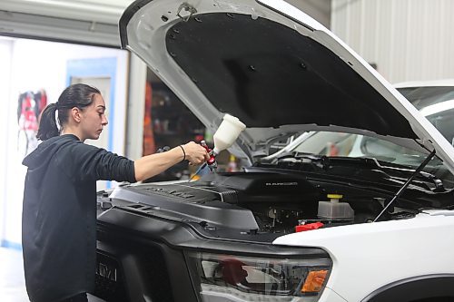 Lainey Fidler, detailer with Resurrection Auto Detailing Tint and Protection applies a protective coat on a truck engine at the company's shop in Brandon on Thursday. (Michele McDougall/The Brandon Sun) 
